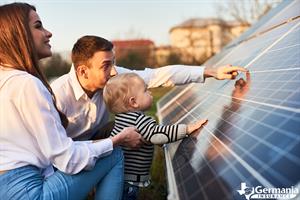 Parents showing their young child a solar panel array