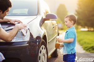 Father and son cleaning a car