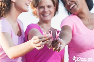 Several woman holding pink breast cancer awareness ribbons