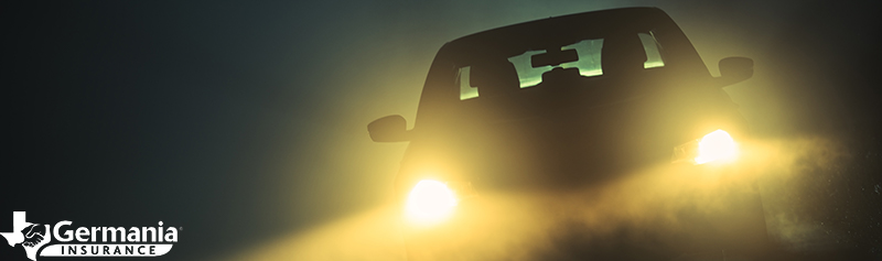 A car with bright headlights driving at night