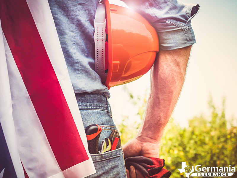 A man with a hard hat and American flag representing the history of Labor Day in the USA