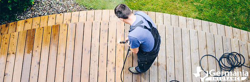 Homeowner power washing deck for preventative maintenance