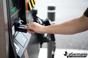 A man using a credit card to pay at a gas station
