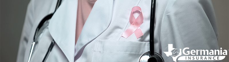 A doctor with a pink breast cancer awareness ribbon on her coat
