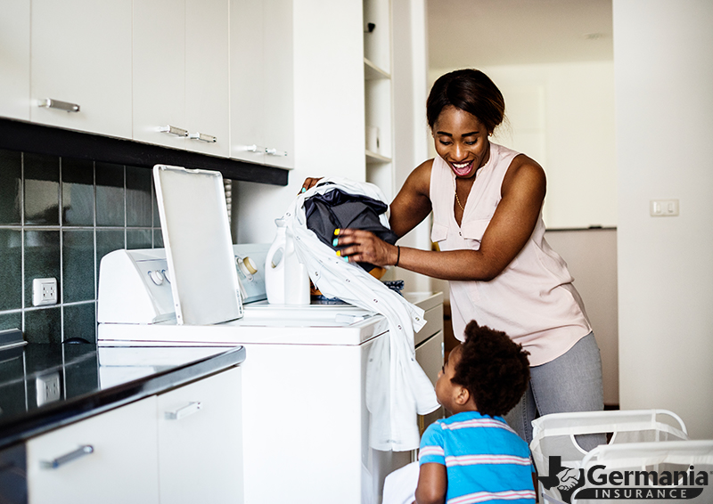 A mother and son using a dryer to do their laundry