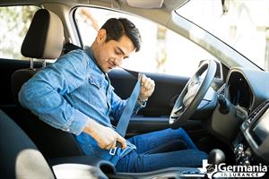 A man putting on a seat belt passive restraint system