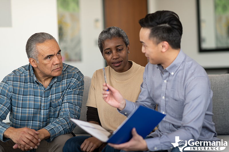 An elderly family speaking to their insurance agent about what happens when their term life policy expires.