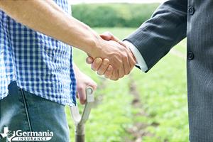 A farmer shaking hands with a farm mutual insurance company agent.