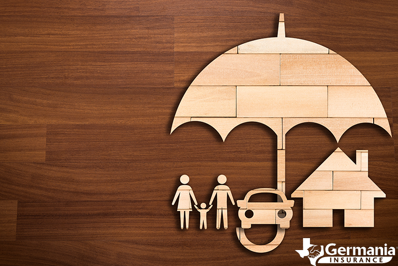 A wooden cutout depicting a family and their assets covered by umbrella insurance.