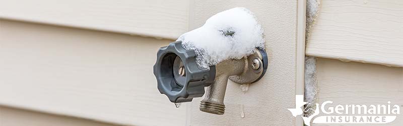 An outdoor faucet with snow on it