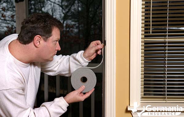 A man winterizing a door with weatherstripping